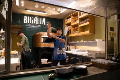 El show de los pizzaiolos revoleando la masa estirada a mano antes de llevarla al horno de piedra refractaria fabricado a mano en Nápoles.