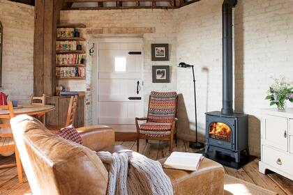 El sillón de cuero frente a la salamandra invita a elegir un libro y sumergirse en la fantasía.