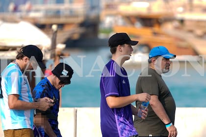 El sindicalista-empresario kirchnerista Víctor Santa María camina por la bahía de Doha con familiares y amigos; atrás suyo, con gorro estilo piluso con la leyenda "Perón volvió", uno de sus hijos