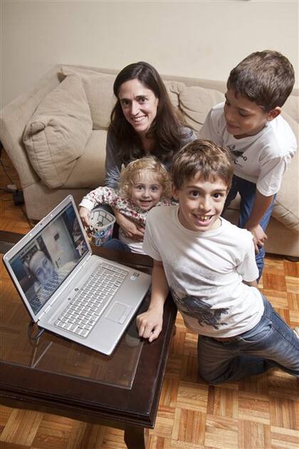 Juan Alfonso Pegasano, en la pantalla de la notebook; su esposa, María Magdalena; los mellizos Tomás y Francisco, y la pequeña Josefina