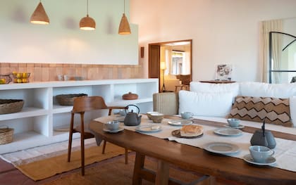 El sofá de mimbre se vistió con un nuevo conjunto de almohadones con funda y almohadón en fibras naturales (Malena y Ana). Alfombras de lana de oveja tejida en telar (Puskano Alfombras).