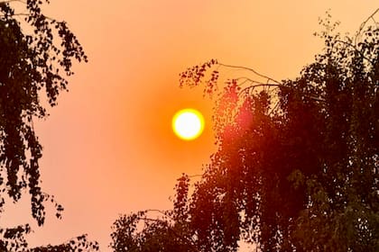 El sol apenas visible detrás de la nube de humo que cubre la ciudad durante el día