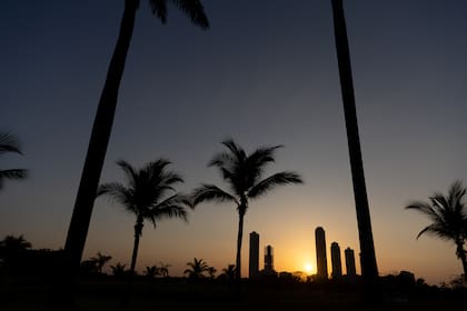 El sol comienza a asomar entre los edificios y las palmeras en el Santa María Golf Club de Panamá.