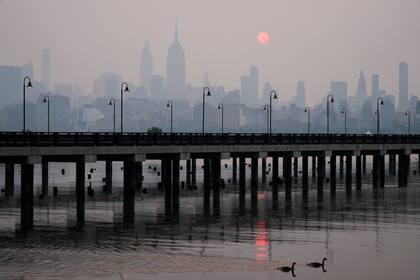 El sol sale sobre un horizonte brumoso de la ciudad de Nueva York visto desde Jersey City