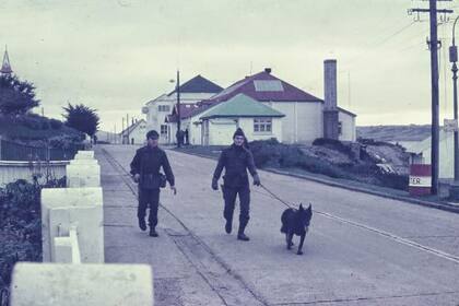 El soldado Jorge Rinaldi patrullando las calles de Puerto Argentino con el perro "Nick". La foto pertenece al corresponsal de guerra Eduardo Rotondo.