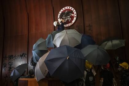 Un hombre pinta sobre el emblema regional de Hong Kong en el Complejo del Consejo Legislativo