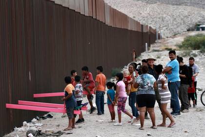 Los niños juegan en el subibaja instalado en Ciudad Juárez, en el muro fronterizo que separa México de los Estados Unidos