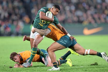 El sudafricano Grant Williams avanza entre dos australianos y es tacleado por Len Ikitau durante el comienzo del Rugby Championship en el Ellis Park Stadium de Johannesburgo