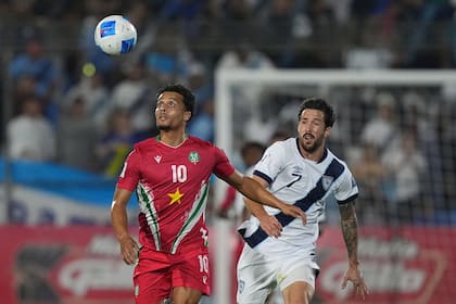 El surinamés Denzel Jubitana (izquierda) y el guatemalteco Aaron Herrera disputan el balón durante un partido de clasificación para la Copa Mundial de Fútbol de 2026 en Ciudad de Guatemala, el martes 18 de noviembre de 2025. (Foto AP/Moisés Castillo)
