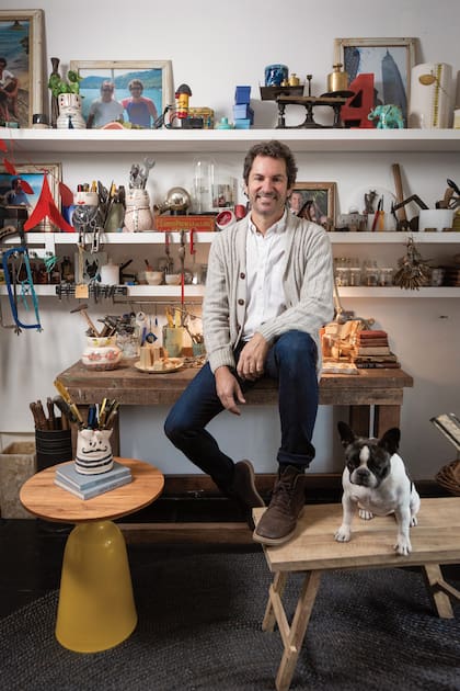 El taller de Sebastián, con un banco de carpintero y repleto de fotos familiares, recuerdos de viajes y herramientas que guarda en las vasijas que hizo en sus clases de cerámica (como la que se apoya sobre la mesita amarilla con tapa de madera de Salazar Casa). Pebeta, a su lado, muy fotogénica y atenta a los flashes.