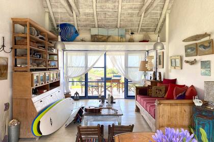 El techo de paja pintado de blanco y los tirantes de tronco rústicos acompañan el espíritu surfer del lugar.