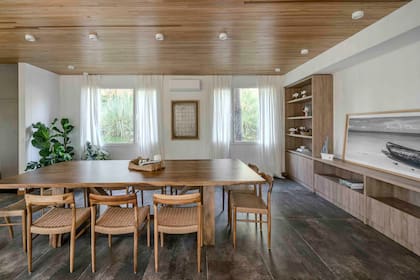 El techo se revistió con listones de cielorraso kiri (De Las Misiones) y el piso con porcelanato Óxido Marrón (Cerámica Alberdi). Mesa en madera maciza de laurel y sillas de petiribí (MAB Amoblamientos). Cortinas (Esteve Quintana).