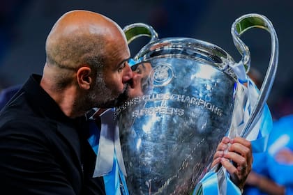 El técnico del Manchester City Pep Guardiola le da un beso a la Champions League que ganó al vencer al Inter de Milán, el 10 de junio de 2023