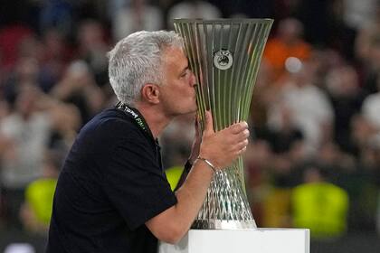 El técnico portugués José Mourinho, de la Roma, besa el trofeo de la UEFA Conference League