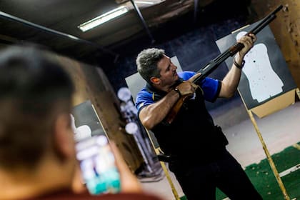 El tendero brasileño Anderson Lessa posa para una foto con un rifle calibre 12