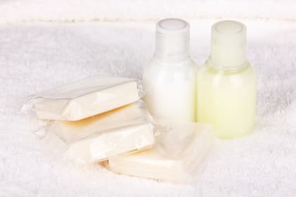 El texto prohíbe botellas de hasta 177 ml con champú, jabón líquido, acondicionador o enjuague bucal en baños o habitaciones
