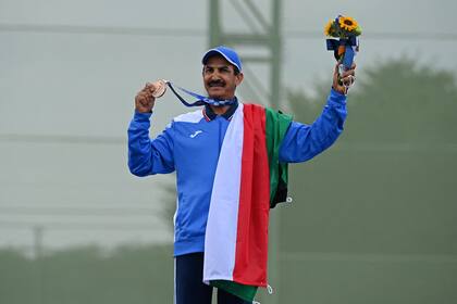 El tirador kuwaití Abdullah Alrashidi, de 57 años, posa con la medalla de bronce en skeet; había ganado la misma presea en Río 2016, pero como atleta independiente, ya que su país estaba suspendido