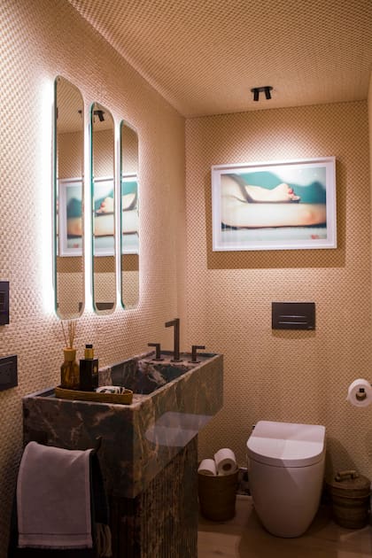 El toilette de Concepto Fusión en Experiencia Living 2025 combina lo vintage y lo contemporáneo: el entelado de ragia aporta textura y un toque retro, mientras que los espejos se asocian por reflejo y luz a la obra de arte