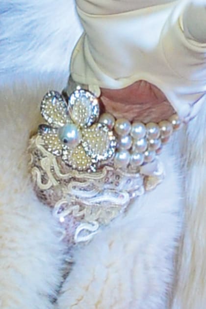 El touch de diva sobre su guante: una pulsera con triple vuelta de perlas que remata en superbroche.