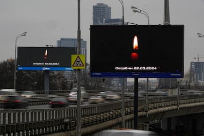 El tráfico circula por la autopista junto a un cartel en que dice "Lloramos al 03.22.2024" en Moscú, Rusia, el sábado 23 de marzo de 2024, tras un ataque el viernes reivindicado por el grupo Estado Islámico. 
