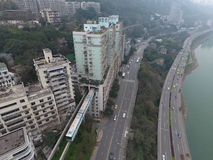 El tren atraviesa un edificio residencial sin alterar la vida diaria, una muestra de la armonía entre innovación urbana y densidad poblacional