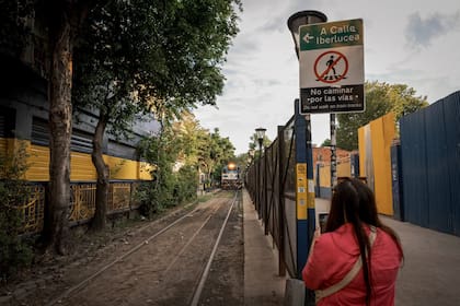 El tren avanza rumbo al Riachuelo tras pasar junto a la Bombonera: una turista china retrata la escena