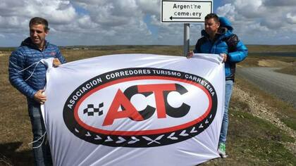 Giani, Ortelli y una bandera de la ACTC en el cementerio argentino de Darwin, de la isla Soledad