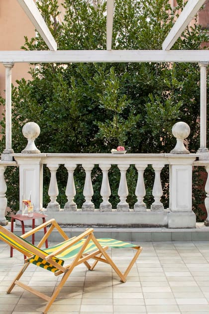 El último nivel se expande hacia esta pequeña terraza con balaustrada clásica.