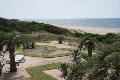 El último sector del jardín, abierto al mar, se planteó como un gran espacio de césped intervenido con formas orgánicas que supieron contener grandes masas de rastreras y ágaves. Hoy queda el diseño y la arena, que acerca la costa a la casa.