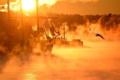 El vapor se eleva desde el agua alrededor de un histórico velero tri-master amarrado en un puerto de Oslo el 5 de enero de 2024. Temperaturas frías inusuales de alrededor de -22 grados. (Olivier MORIN / AFP)�