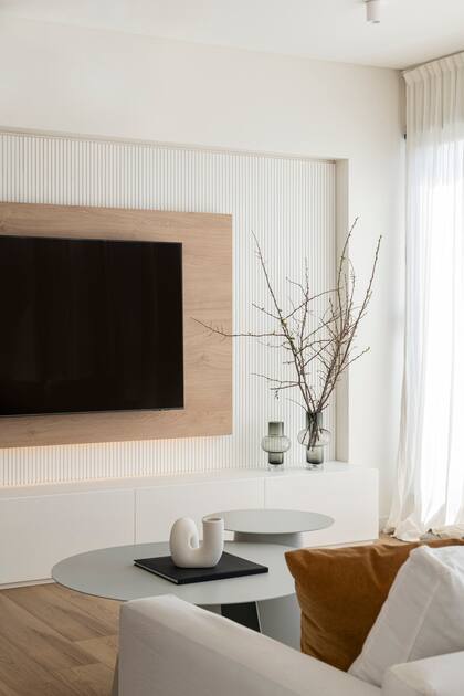 El varillado de MDF se acompañó con un marco de melamina en Roble Kendal Natural. Debajo de la televisión se diseñó un mueble bajo que suma espacio de guardado.