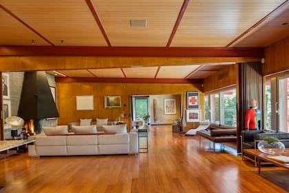 El ventanal de 18 metros de largo ofrece vistas al jardín, donde se alarga la piscina negra.