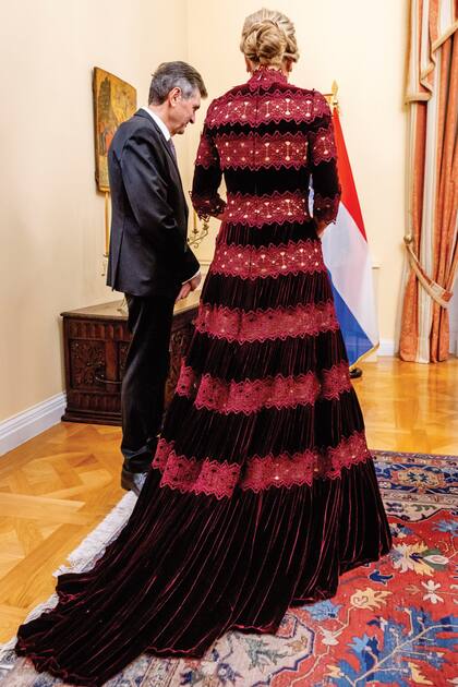 El vestido, de manga al codo, falda línea “A” y cuello perkins, con franjas horizontales de encaje más claro, tenía una cola también de terciopelo.