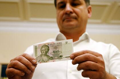 El vicepresidente del Banco Republicano de Transnistria, Aleksei Melnik, muestra un billete de 500 rublos de Transnistria que representa a la emperatriz Catalina II (Sergei GAPON / AFP)