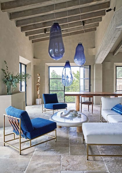 El vidrio es protagonista en el living y el estar, en piezas de vidrio soplado como estas lámparas que retoman el tono azulado del paisaje.