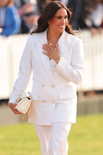 El viernes 15, la mujer del príncipe Harry participó de una recepción previa a la competencia vestida con un pantsuit blanco de Valentino –que complementó con cartera haciendo juego– y el reloj Cartier, un Tank Francais de oro, que perteneció a la princesa Diana.