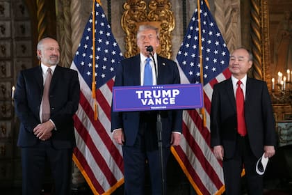 El virtual presidente electo Donald Trump en una conferencia de prensa en Mar-a-Lago, el lunes 16 de diciembre de 2024, en Palm Beach, Florida, acompañado del director general de SoftBank Group, Masayoshi Son, a la derecha, y el nominado a secretario de Comercio, Howard Lutnick. (AP Foto/Evan Vucci)