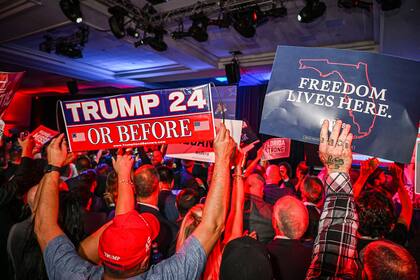 Carteles sobre Trump en un evento de apoyo a Ron DeSantis durante la noche electoral