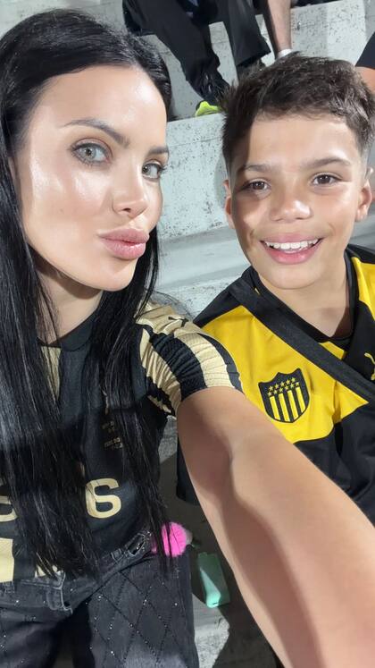 Eliana Díaz y su hijo en el partido de Peñarol ante River Plate argentino