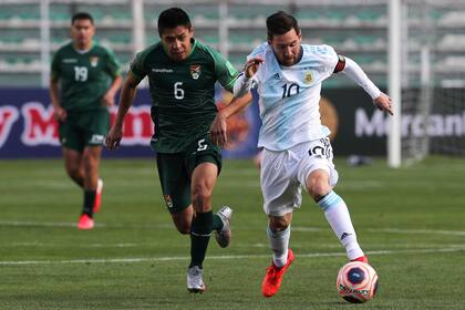 Lionel Messi empezó poco activo en La Paz y fue apareciendo con el correr de los minutos; lo persigue Diego Wayar.