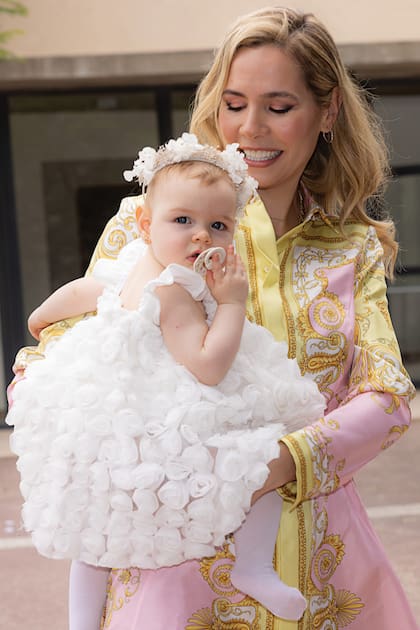 Elina llega a la
parroquia de
Nordelta con su
hija en brazos. La
modelo y empresaria
eligió un minivestido
de Versace, mientras
que Kahlo llevó un
soñado vestido con
rosas aplicadas de
La Blancherie y una
vincha de flores de
Jacinta