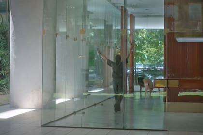 Eliseo, interpretado por Guillermo Francella, recorriendo el hall del edificio en el que trabaja con aerosoles con fragancias para ambientes