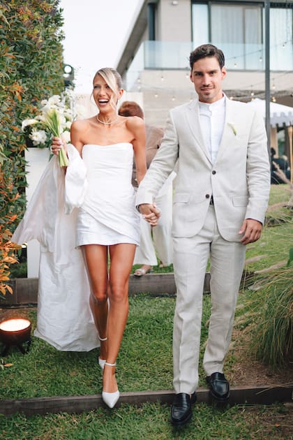 Ella lució un strapless de líneas depuradas, drapeados estratégicos y sobrefalda desmontable realizado por Joti Harriague. Las joyas, de Pandora; y los stilettos, clásicos y con pulsera al tobillo, de Ricky Sarkany. Nico llevó un traje de lino, de Mancini