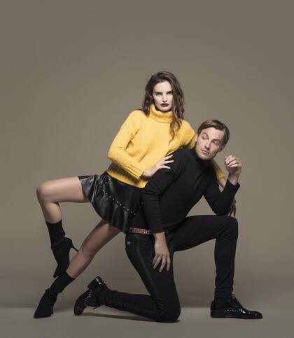 Ella: polera corta de lana gruesa (Complot), minifalda de ecocuero con tachas y volado (Desiderata), botas cortas de neoprene (Sarkany). Él: polera de algodón, pantalón chino y cinturón de cuero con tachas (Bolivia)