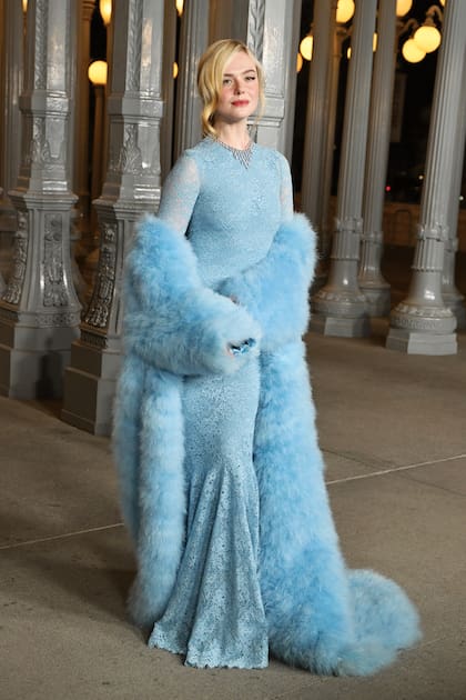 Elle Fanning, con un vestido de corte sirena y mangas largas de encaje, de Gucci, que acompañó con un abrigo de piel sintética y joyas Cartier