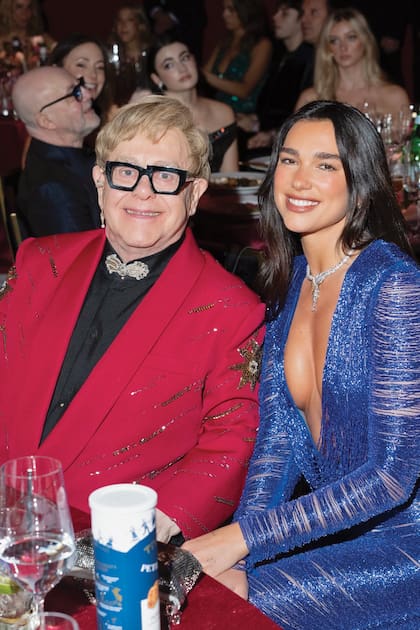 Elton John,
anfitrión de la Viewing Party de la
Fundación de Lucha contra el Sida,
con una de sus invitadas y amigas,
Dua Lipa. La cantante luego cambió el vestido azul de Gucci por un
strapless de Schiaparelli para ir a la
fiesta de Vanity Fair
