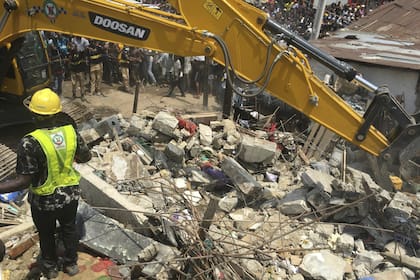 Emergency services attend the scene after a school building collapsed in Lagos, Nigeria, Wednesday March 13, 2019. Rescue efforts are underway in Nigeria after a three-storey school building collapsed while classes were in session, with some scores of children thought to be inside at the time.(AP Ph