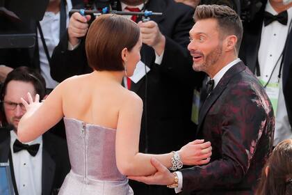 Emilia Clarke, de espalda, junto a un sorprendido Ryan Seacrest, histórico conductor de E!