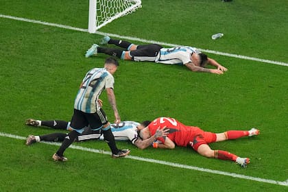 Emiliano Martínez acaba de evitar el 2-2 en el final del partido y varios compañeros lo festejan con alivio.