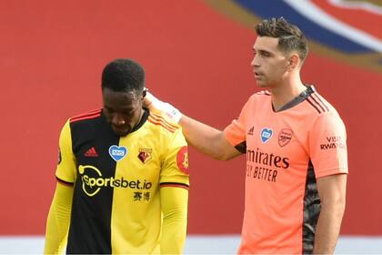 Emiliano Martínez, arquero argentino que tiene Arsenal, consuela a un jugador de Watford, equipo que perdió la categoría este domingo